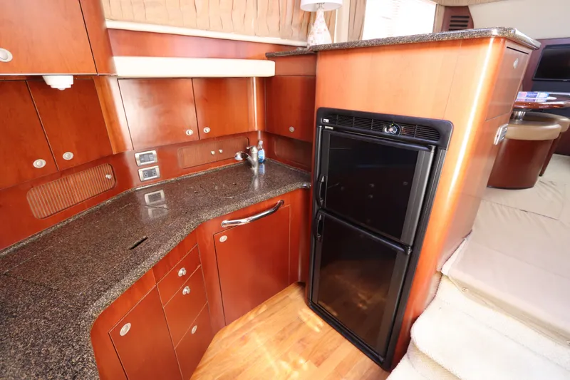 Slide: The Image of Luxurious 2005 Sea Ray 390 Motor Yacht kitchen with wood cabinetry and compact refrigerator. - 41