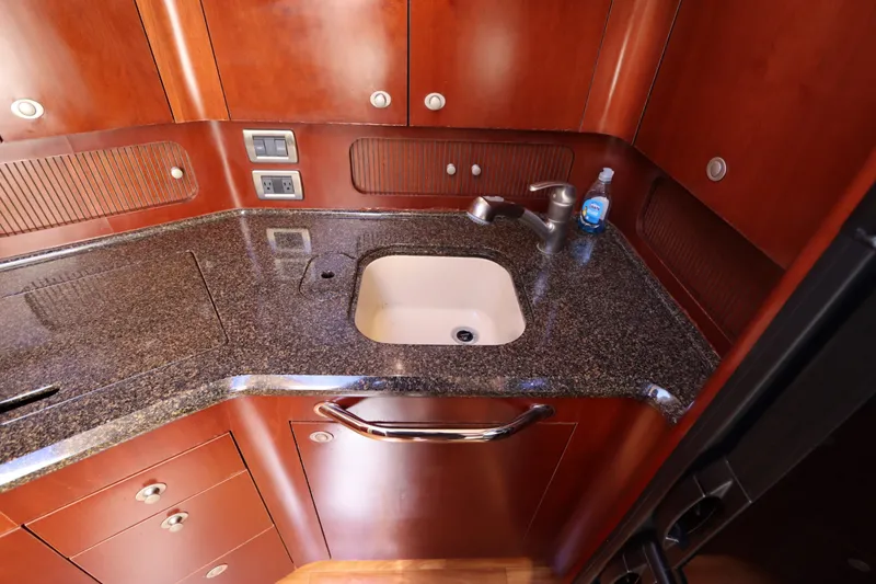 Slide: The Image of Luxurious 2005 Sea Ray 390 Motor Yacht kitchen with granite countertop and wooden cabinetry. - 39