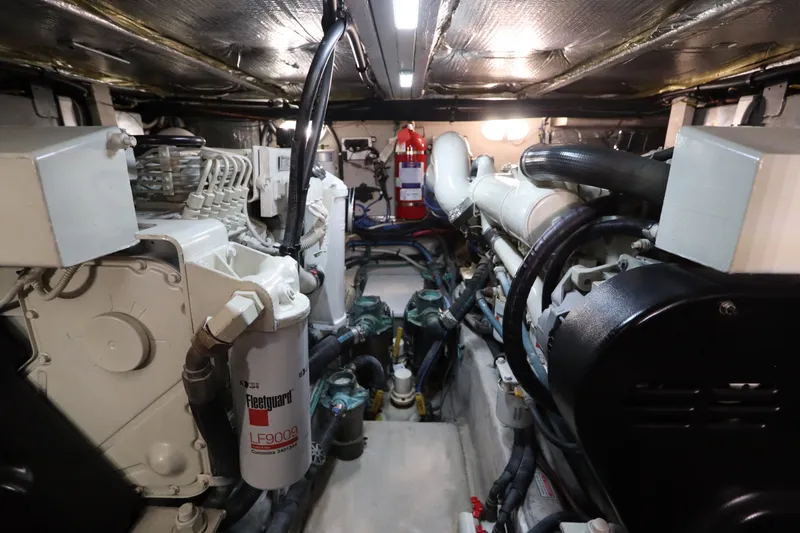 Slide: The Image of Engine room of a 2005 Sea Ray 390 Motor Yacht, featuring mechanical components and fire extinguisher. - 64