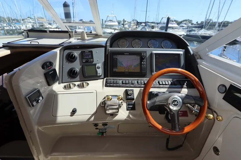 Slide: The Image of 2005 Sea Ray 390 Motor Yacht helm with navigation screens and wooden steering wheel. - 25