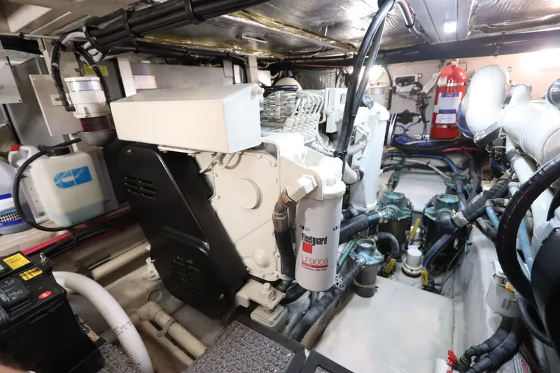 Slide: The Image of Engine room of 2005 Sea Ray 390 Motor Yacht, featuring mechanical components and fire extinguisher. - 63