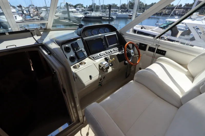 Slide: The Image of 2005 Sea Ray 390 Motor Yacht helm with leather seating and marina view. - 24