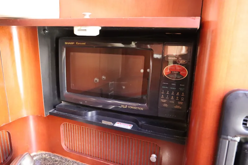 Slide: The Image of Microwave in 2005 Sea Ray 390 Motor Yacht kitchen, featuring wood cabinetry. - 40