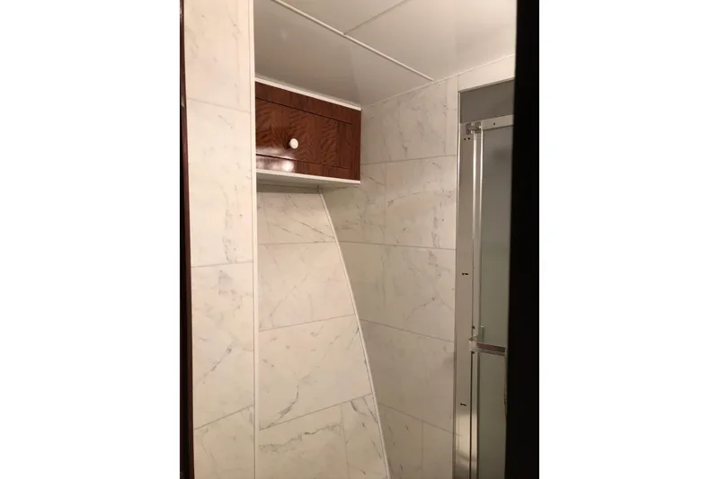 Slide: The Image of Interior of a 1976 Hatteras 53 Convertible with marble walls and a wooden cabinet. - 24