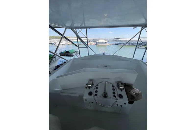 Slide: The Image of Helm of a 1976 Hatteras 53 Convertible overlooking a marina. - 7