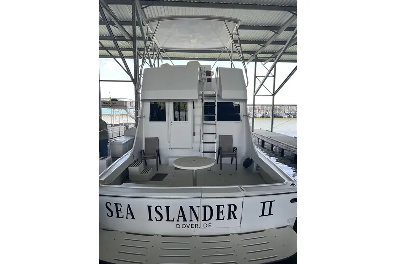 Slide: The Image of Rear view of a 1976 Hatteras 53 Convertible in a harbor, under a covered berth. - 10