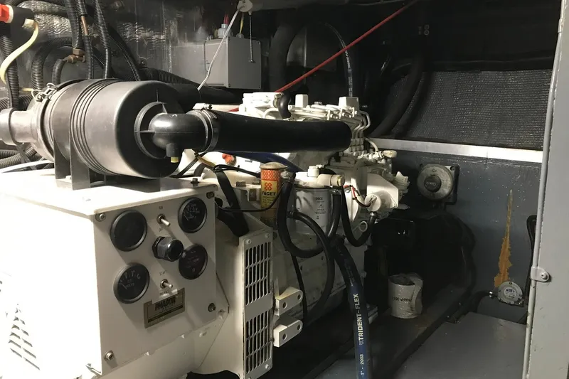 Slide: The Image of Engine room of a 1976 Hatteras 53 Convertible with various machinery and hoses. - 34