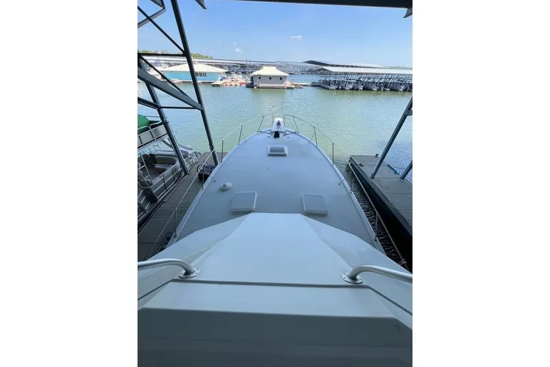 Slide: The Image of 1976 Hatteras 53 Convertible docked, overlooking the water and surrounding boats. - 11