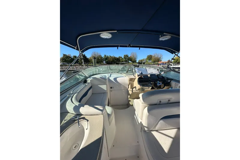 Slide: The Image of 2002 Chaparral Signature 320 boat interior with helm and seating under blue canopy. - 15