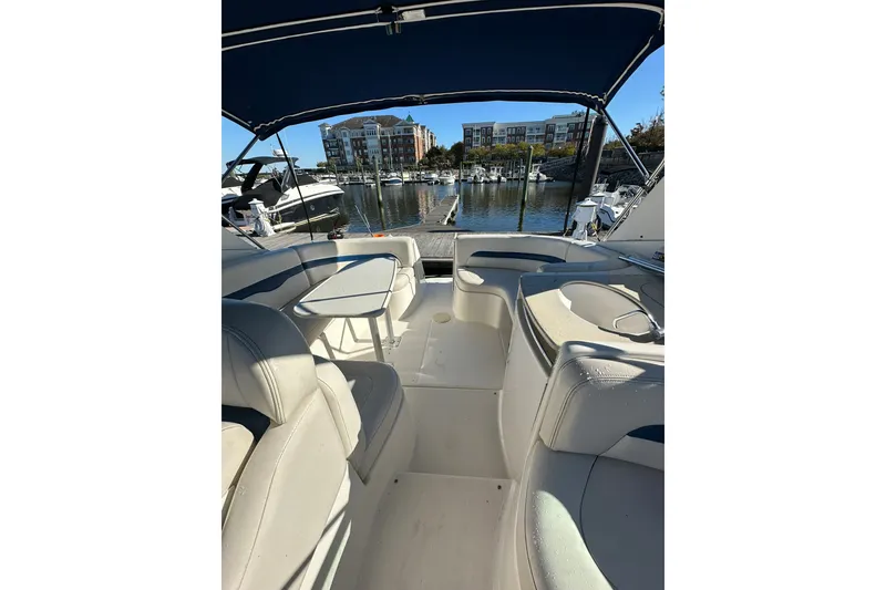 Slide: The Image of 2002 Chaparral Signature 320 boat interior with seating and table, docked at marina. - 16