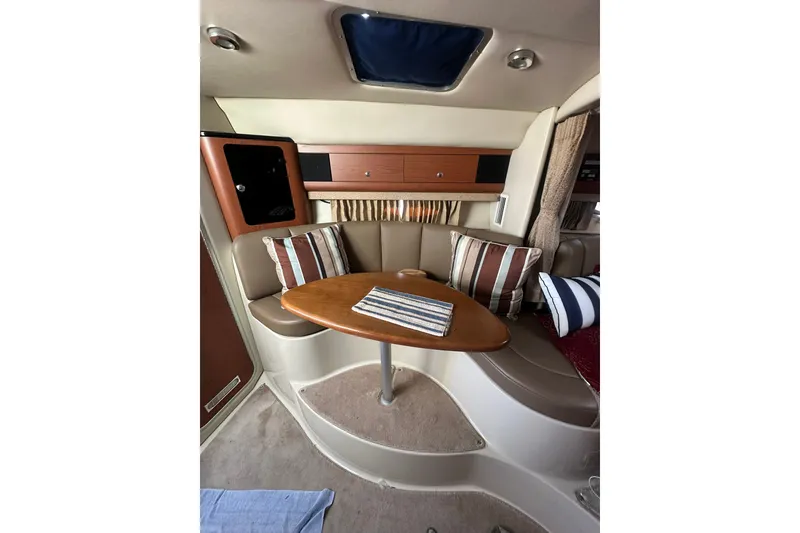 Slide: The Image of Interior of 2002 Chaparral Signature 320 boat with cozy seating and wooden table. - 18
