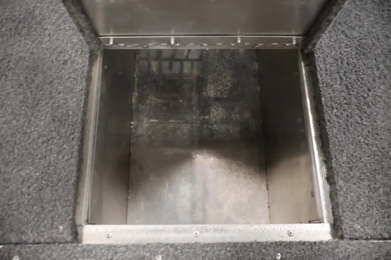 Slide: The Image of Open storage compartment in 2019 Tracker Pro 170 boat, featuring carpeted edges. - 17