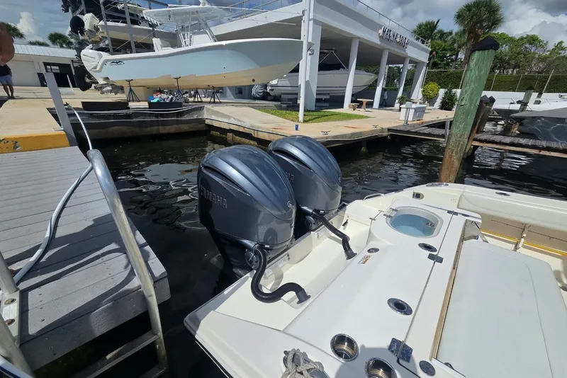 Slide: The Image of 2022 Cobia 280 Center Console boat docked with dual Yamaha outboard engines. - 9