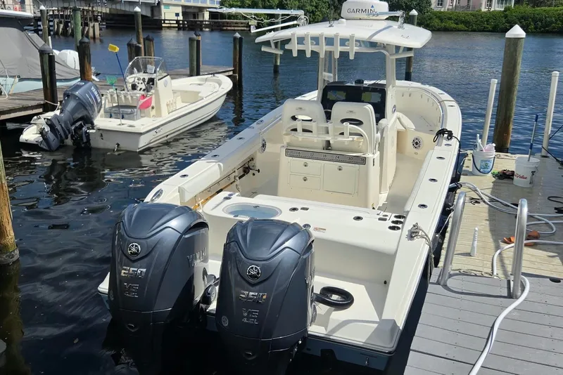 Slide: The Image of 2022 Cobia 280 Center Console boat docked with twin Yamaha engines. - 7