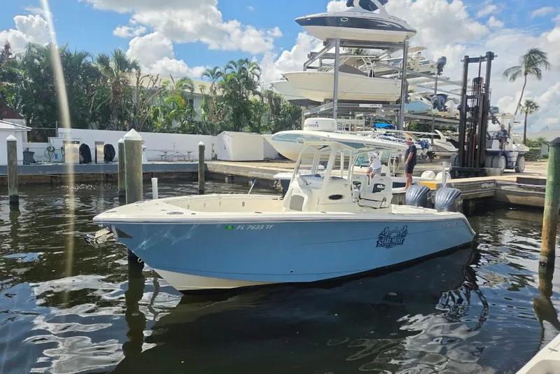 Slide: The Image of 2022 Cobia 280 Center Console boat docked at marina under sunny skies. - 3