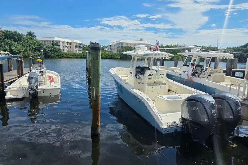 Slide: The Image of 2022 Cobia 280 Center Console boat docked with twin Yamaha engines. - 5