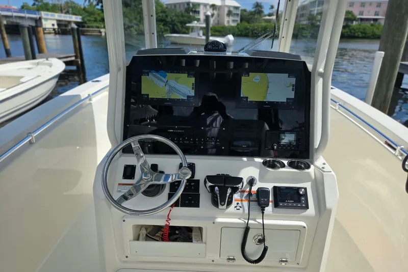 Slide: The Image of Center console of 2022 Cobia 280 boat with navigation screens and steering wheel. - 13