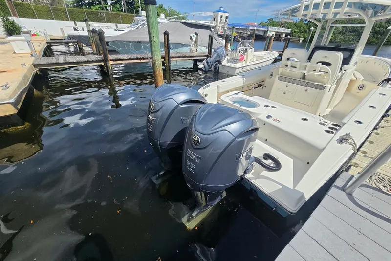 Slide: The Image of 2022 Cobia 280 Center Console boat docked with dual Yamaha outboard engines. - 8