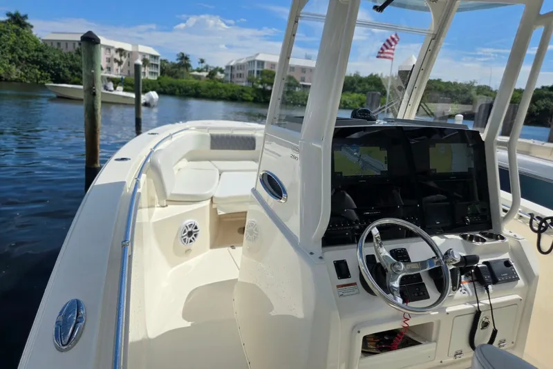 Slide: The Image of 2022 Cobia 280 Center Console boat docked, featuring modern navigation equipment and spacious seating. - 14