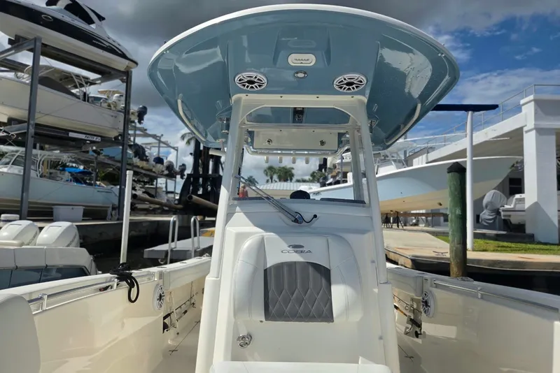 Slide: The Image of 2022 Cobia 280 Center Console boat docked, showcasing helm and seating area. - 21