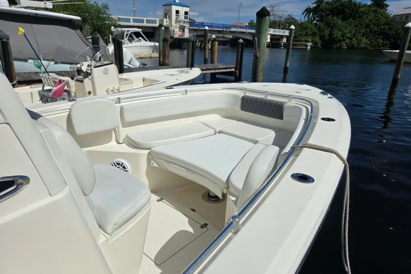 Slide: The Image of 2022 Cobia 280 Center Console boat with spacious seating at a marina. - 17
