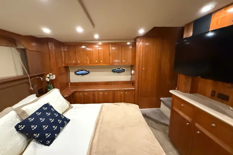 Slide: The Image of Luxurious 2004 Cruisers Yachts 405 Express Motoryacht bedroom with wood cabinetry and modern amenities. - 77