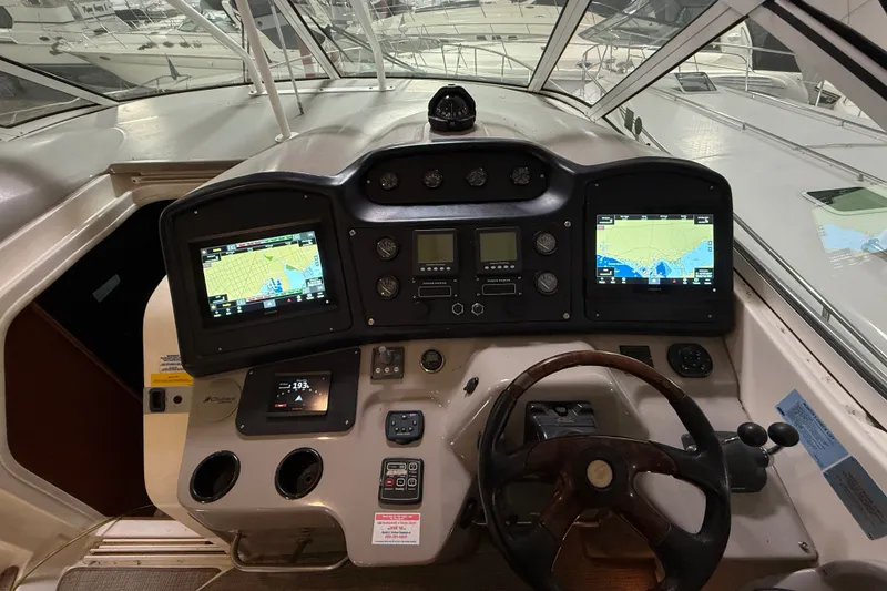 Slide: The Image of 2004 Cruisers Yachts 405 Express Motoryacht helm with navigation screens and controls. - 27