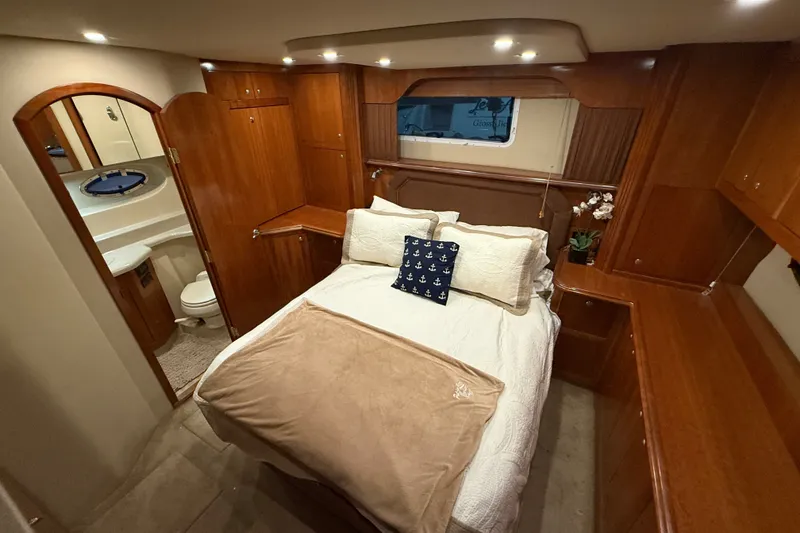 Slide: The Image of Luxurious 2004 Cruisers Yachts 405 Express Motoryacht bedroom with ensuite bathroom and elegant wood finishes. - 72