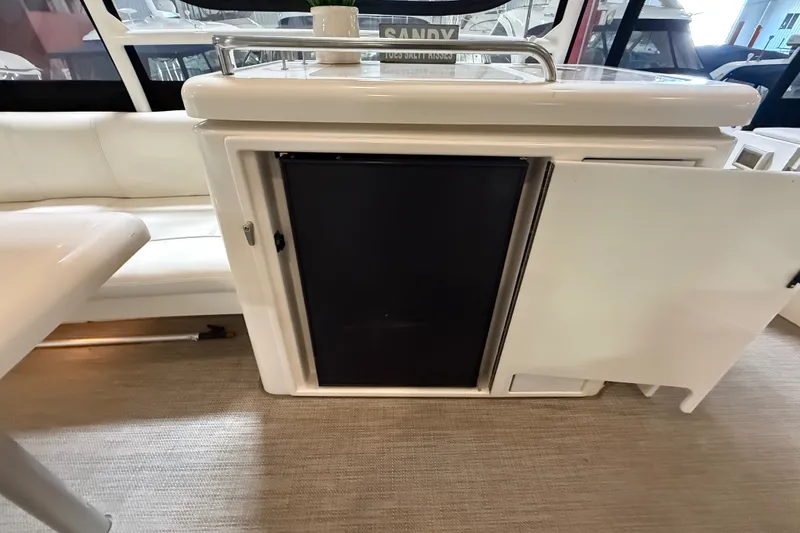 Slide: The Image of 2004 Cruisers Yachts 405 Express Motoryacht interior with open cabinet and seating area. - 12