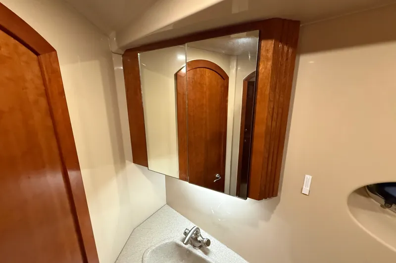 Slide: The Image of Bathroom vanity with mirrored cabinet in 2004 Cruisers Yachts 405 Express Motoryacht. - 67