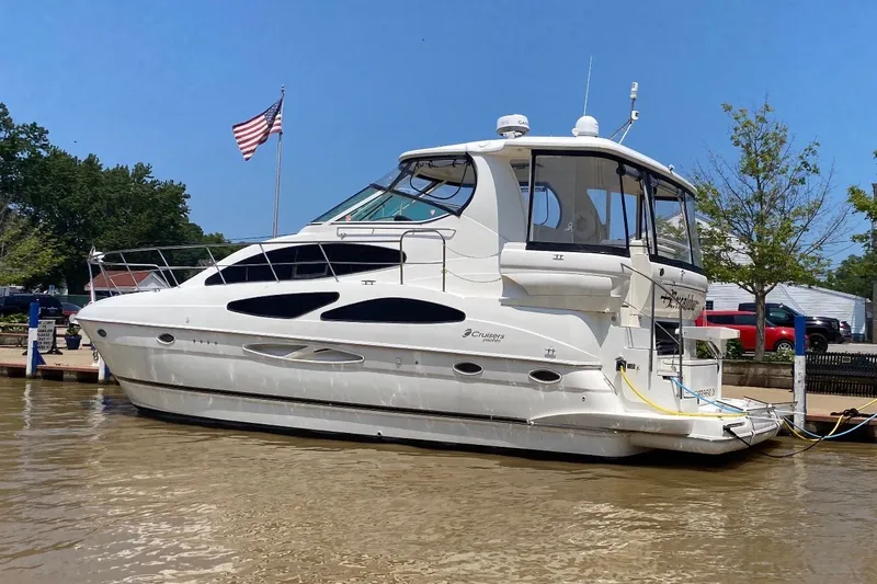 The Image of 2004 Cruisers Yachts 405 Express Motoryacht docked, American flag in background. - 0