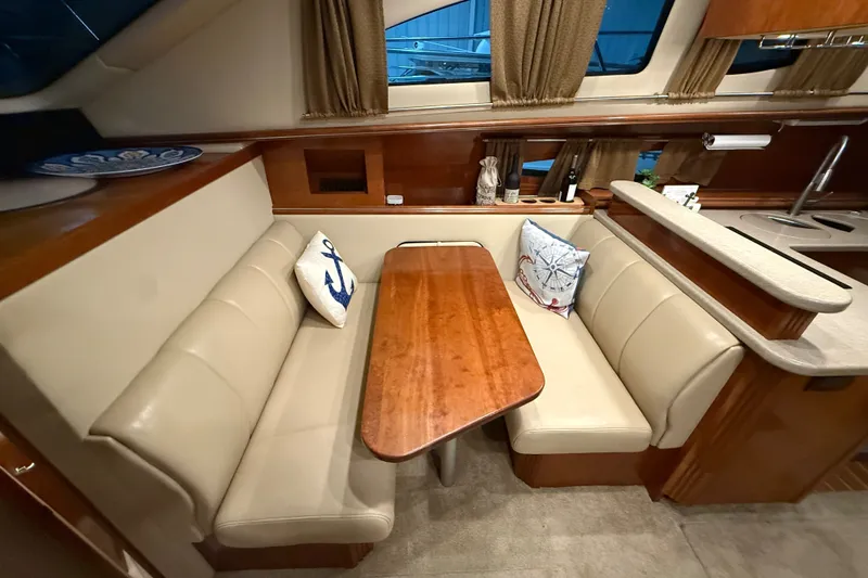 Slide: The Image of 2004 Cruisers Yachts 405 Express Motoryacht interior with beige seating and wooden table. - 50