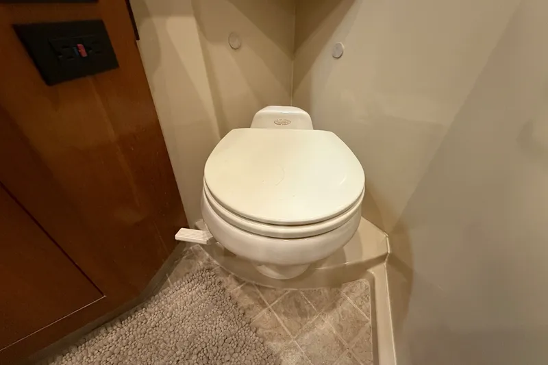 Slide: The Image of Toilet in 2004 Cruisers Yachts 405 Express Motoryacht bathroom, featuring beige walls and flooring. - 85