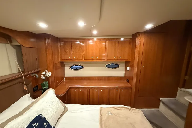 Slide: The Image of Luxurious 2004 Cruisers Yachts 405 Express Motoryacht cabin with wood cabinetry and cozy bedding. - 75