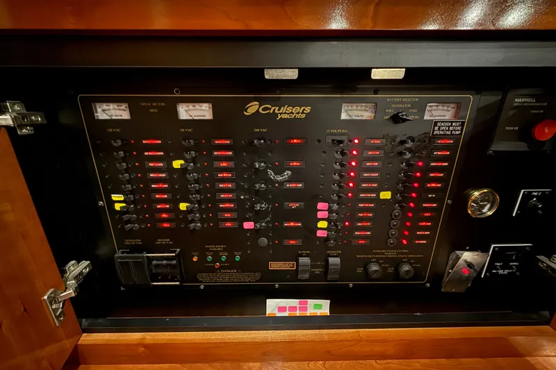 Slide: The Image of Electrical control panel of a 2004 Cruisers Yachts 405 Express Motoryacht with labeled switches and meters. - 89