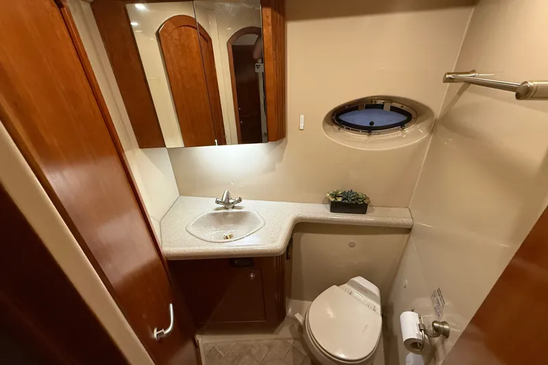 Slide: The Image of Luxurious 2004 Cruisers Yachts 405 Express Motoryacht bathroom with sink, toilet, and porthole window. - 63