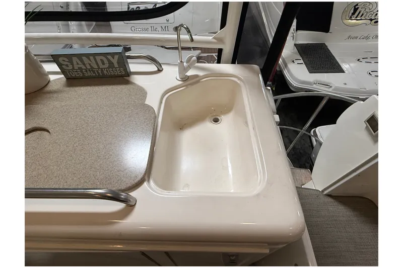 Slide: The Image of 2004 Cruisers Yachts 405 Express Motoryacht sink area with countertop and decor sign. - 14