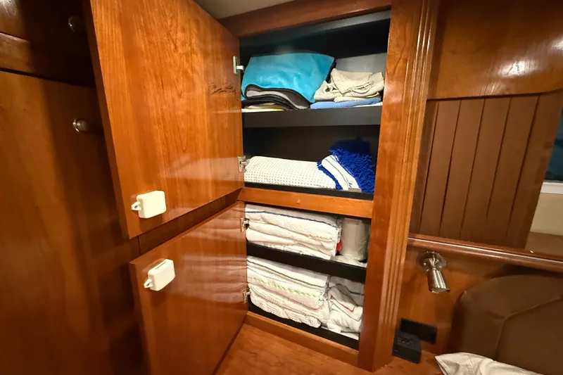 Slide: The Image of Wooden cabinet with neatly stacked towels inside a 2004 Cruisers Yachts 405 Express Motoryacht. - 80