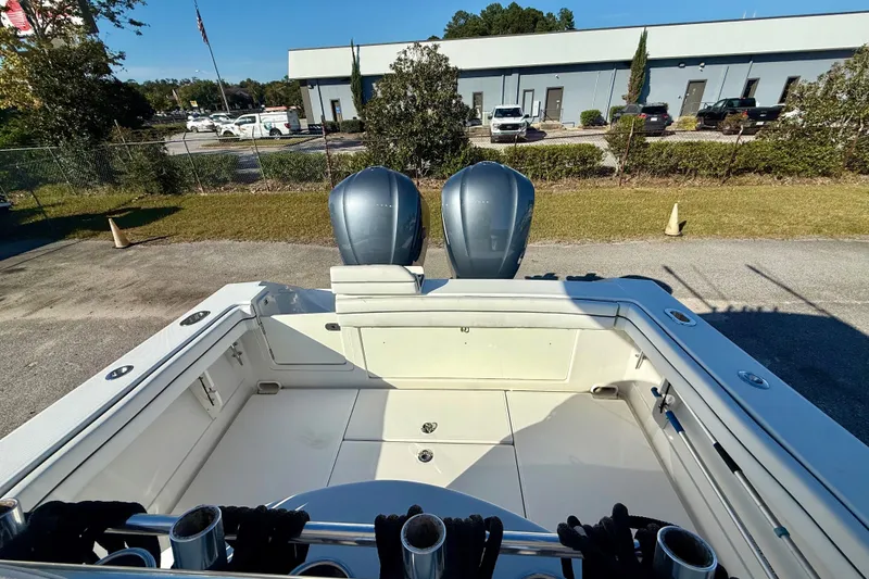 Slide: The Image of 2018 Jupiter 30 HFS boat with dual engines, parked outdoors near a commercial building. - 6