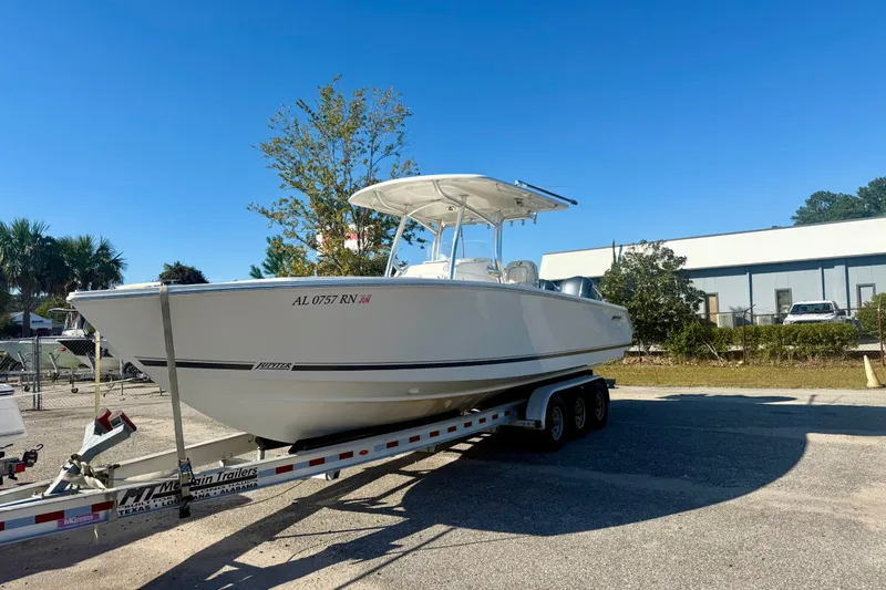Slide: The Image of 2018 Jupiter 30 HFS boat on trailer, parked outdoors under clear blue sky. - 2