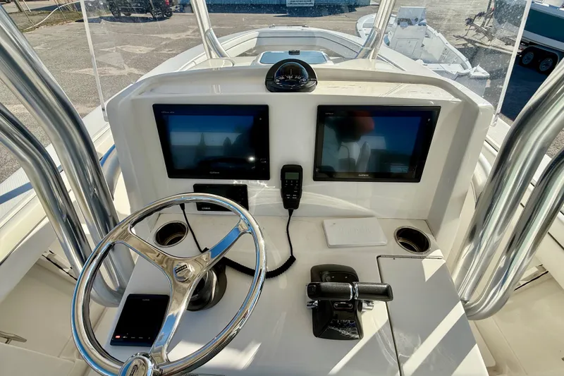 Slide: The Image of Control panel of a 2018 Jupiter 30 HFS boat with dual screens and steering wheel. - 8