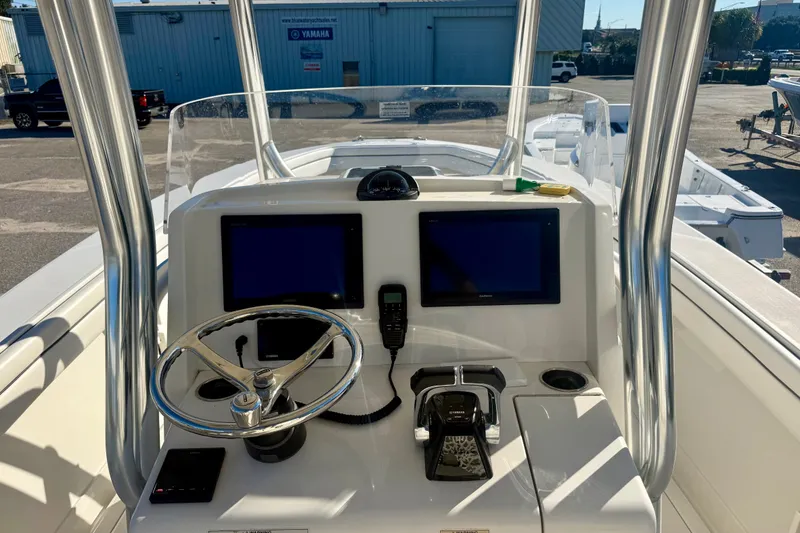 Slide: The Image of Control console of a 2018 Jupiter 30 HFS boat with dual screens and steering wheel. - 3