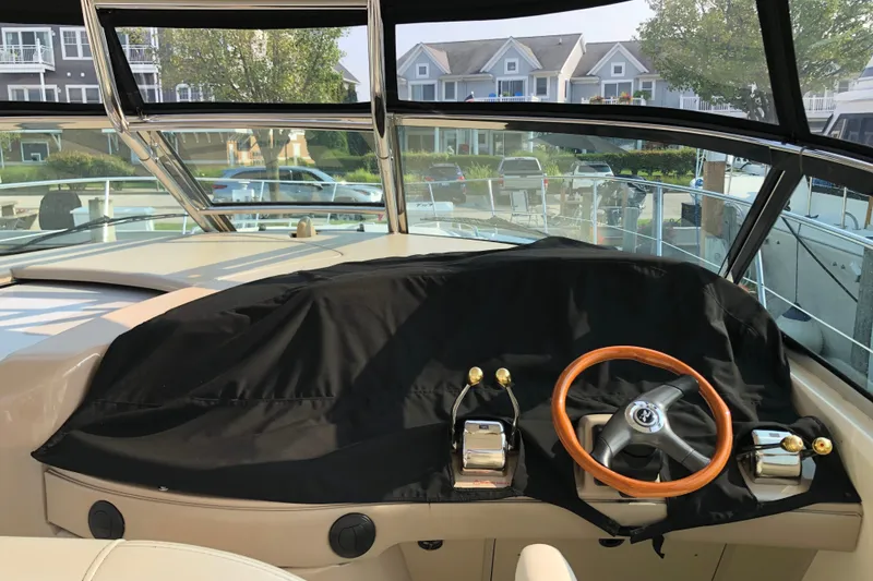 Slide: The Image of Helm of 2004 Sea Ray 420 Sundancer with covered controls and wooden steering wheel. - 6
