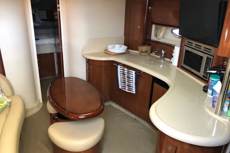 Slide: The Image of 2004 Sea Ray 420 Sundancer interior with kitchenette, dining area, and modern amenities. - 18