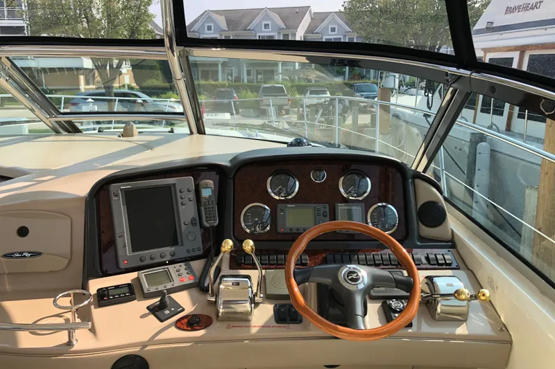 Slide: The Image of Helm of 2004 Sea Ray 420 Sundancer with navigation instruments and wooden steering wheel. - 5