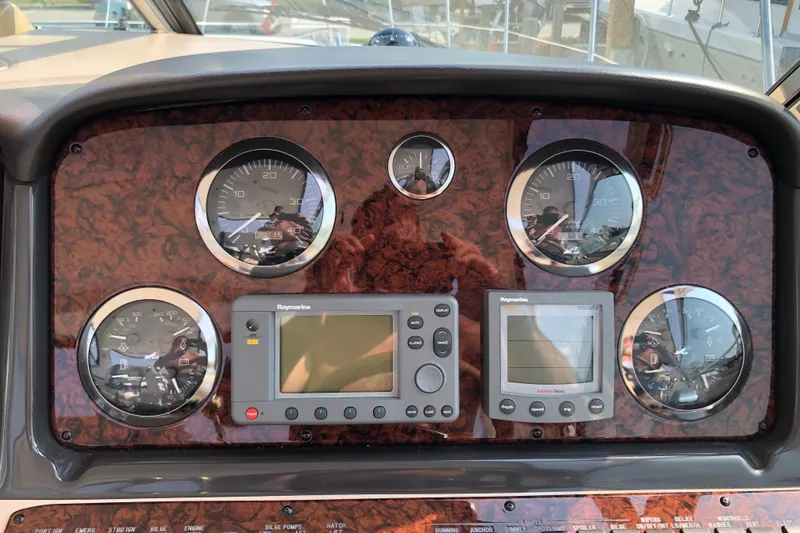 Slide: The Image of Dashboard of 2004 Sea Ray 420 Sundancer with gauges and Raymarine displays. - 7