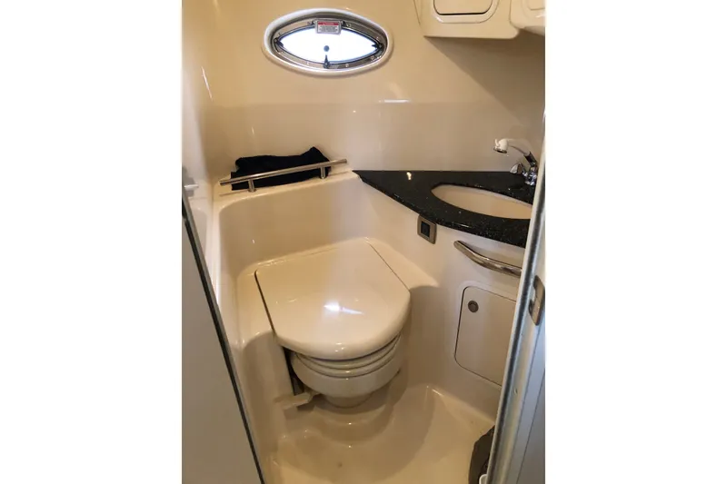 Slide: The Image of 2004 Sea Ray 420 Sundancer bathroom with toilet, sink, and porthole window. - 27