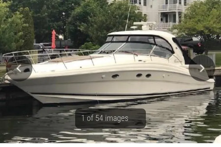 Slide: The Image of 2004 Sea Ray 420 Sundancer yacht docked by waterfront homes. - 3