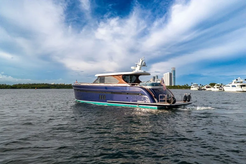 Slide: The Image of Luxury Steeler 60S yacht cruising on water, 2021 model, with city skyline in background. - 37