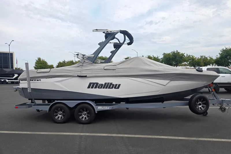 Slide: The Image of 2025 Malibu Wakesetter 23 LSV boat covered on trailer in parking lot. - 25